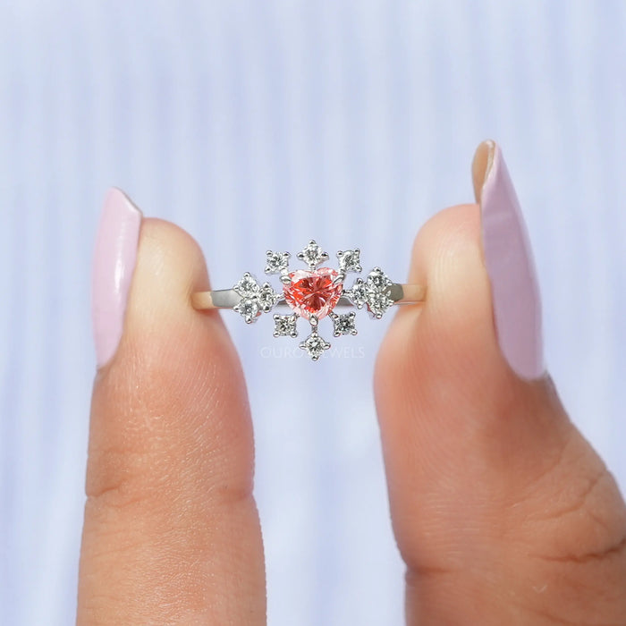 A close up look of lustrous pink heart shape lab made diamond ring with round brilliant cut diamonds