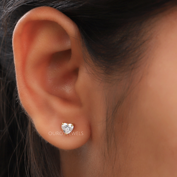 heart shaped lab-grown diamond gold stud earrings on models ear