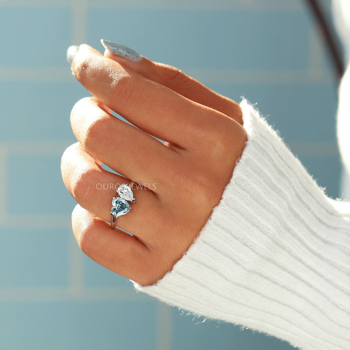 blue heart and pear-cut lab diamond toi et moi wedding ring on model's finger
