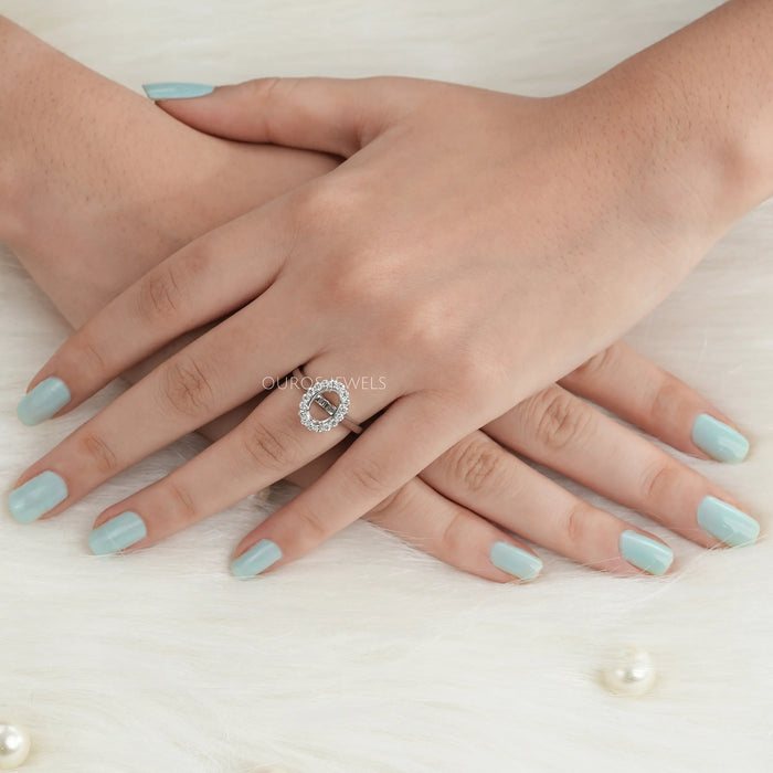 oval-shaped halo semi-mount engagement ring in finger with white gold band