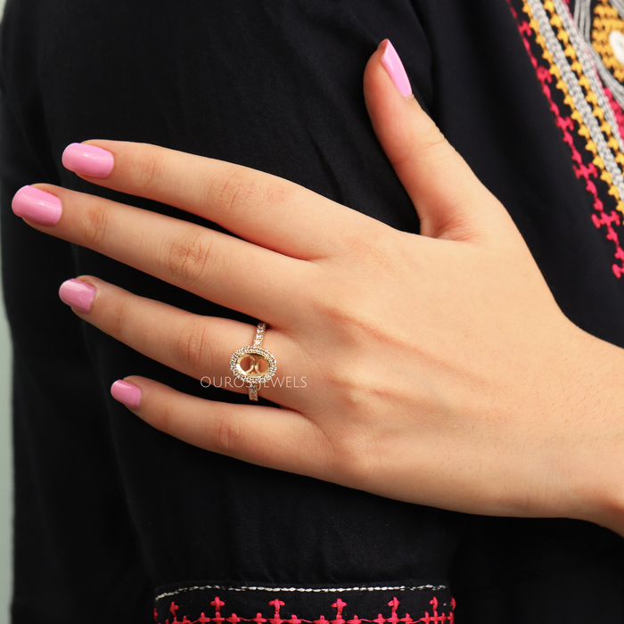 oval-shaped round diamond halo semi-mount engagement ring on model's finger