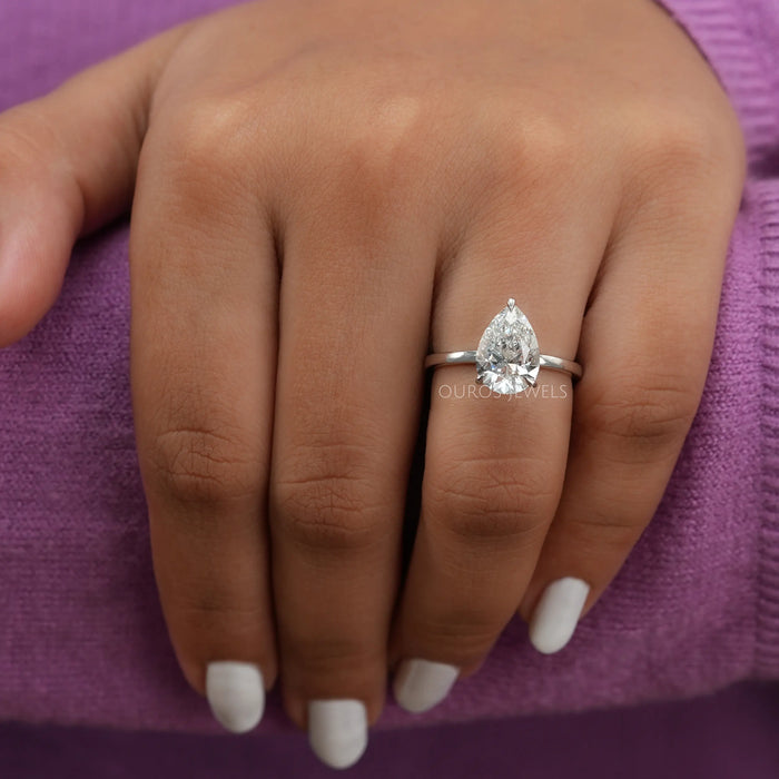 pear cut certified diamond solitaire engagement ring in model's finger
