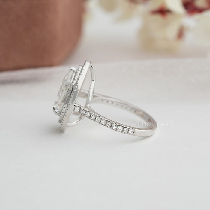 pear cut lab diamond double halo engagement ring's side view on grey fabric