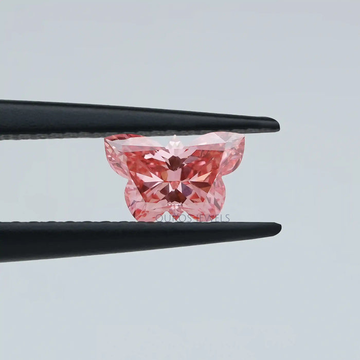 0.50 carat loose lab grown pink diamond butterfly cut held with tweezer