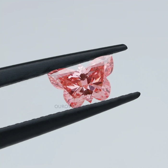 0.50 carat pink butterfly cut loose lab created diamond held with tweezer