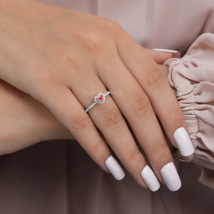 pink heart cut lab grown diamond halo engagement ring on model's finger