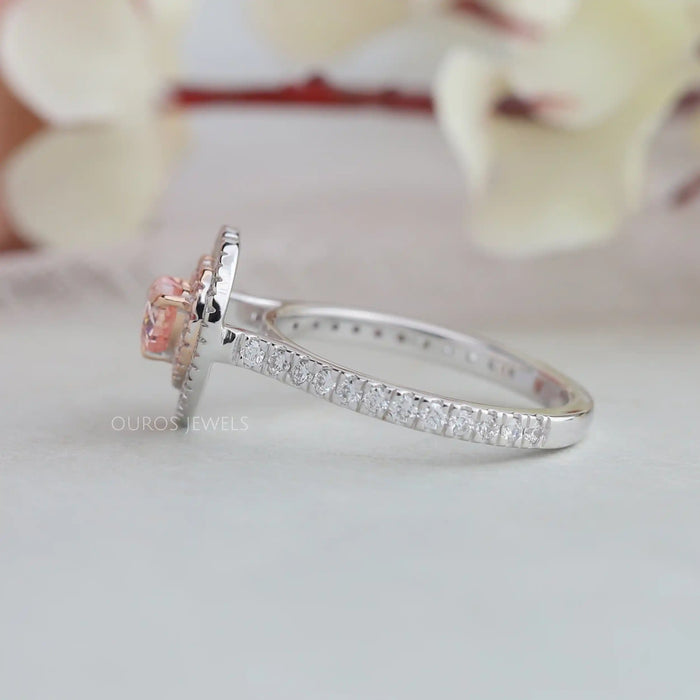 pink heart cut diamond double halo engagement ring's side view on grey fabric