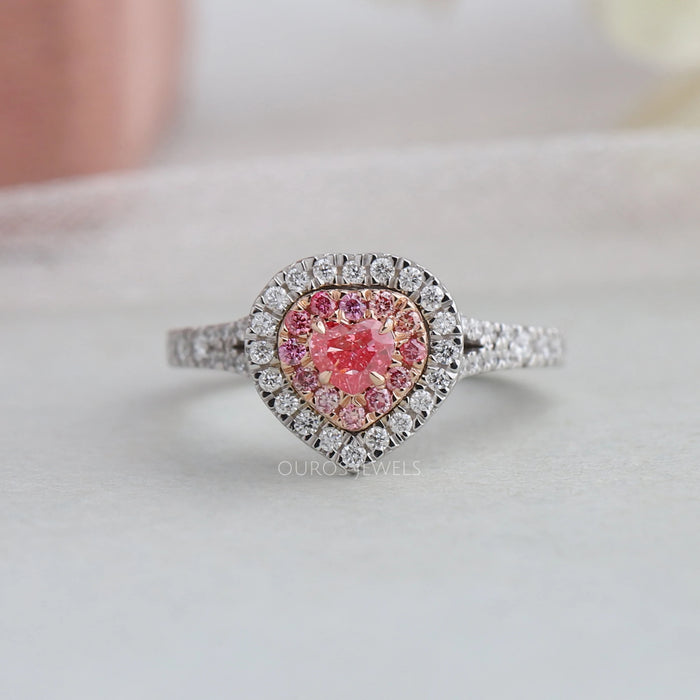 top view of pink heart shaped diamond double halo engagement ring on grey fabric