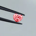 pink heart shaped lab created diamond held with tweezer