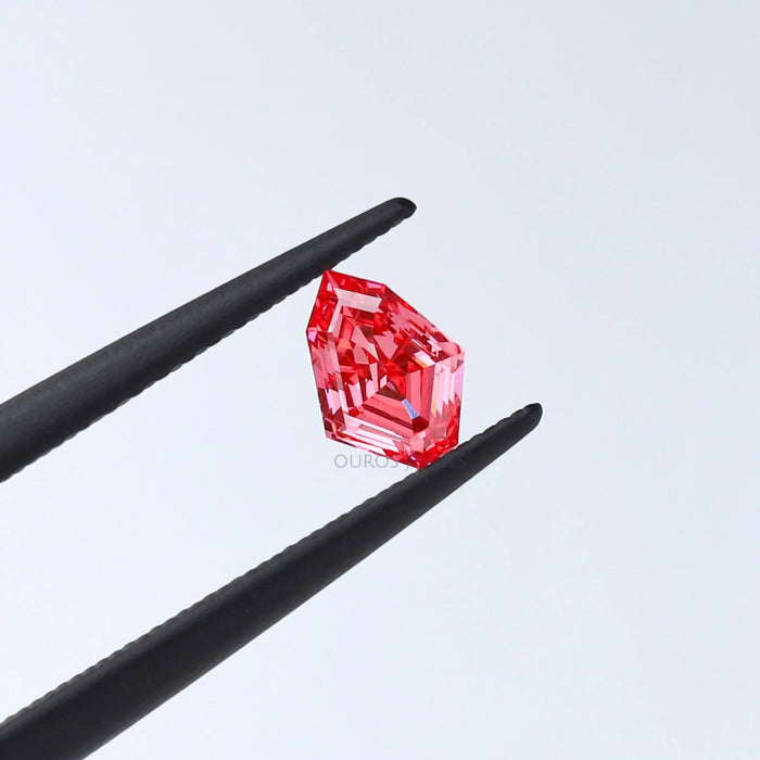pink shield cut man made diamond loose held with tweezer