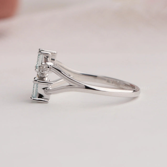 side view of green princess-cut lab diamond dainty wedding ring on grey fabric