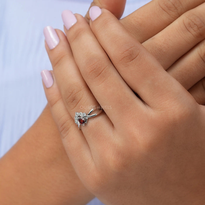 In finger front view of red oval infinity diamond ring crafted with 14k white gold.