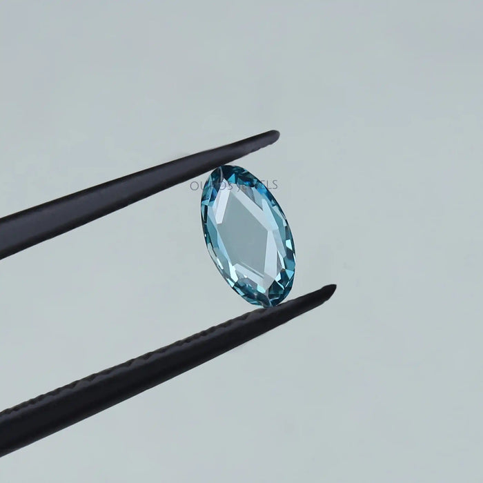 0.53 carat rose cut blue oval cut lab grown diamond loose held with tweezer