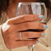 round-shaped prong-setting semi-mount engagement ring on model's finger with drink glass