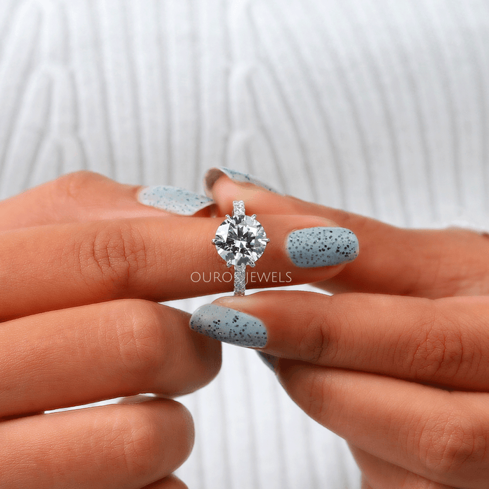 close view of six-prong round-cut lab diamond solitaire wedding ring in finger