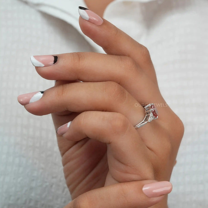 In finger side look of pink cushion 3 stone diamond engagement ring