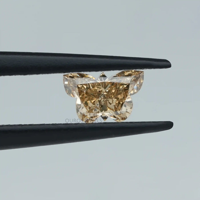 0.40ct yellow butterfly cut diamond man made held with tweezer